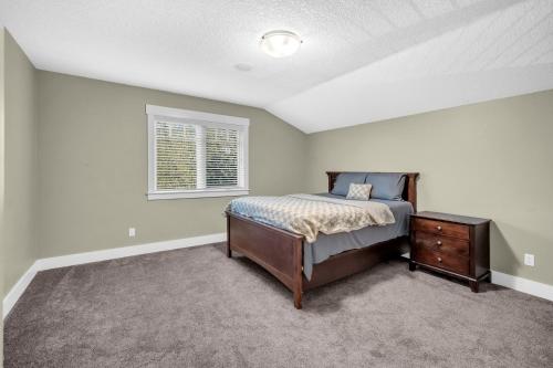 een slaapkamer met een bed, een ladekast en een raam bij Rocky View Bed & Breakfast in Calgary