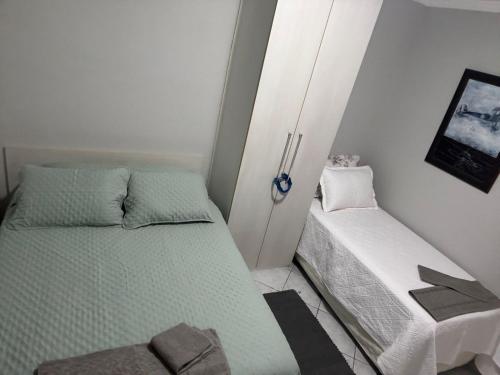 ein kleines Schlafzimmer mit 2 Betten in einem Zimmer in der Unterkunft Apto 2 dorm - Requinte na Praia Grande - SP in Praia Grande