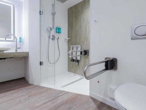 a bathroom with a shower and a toilet and a sink at Novotel Luxembourg Centre in Luxembourg