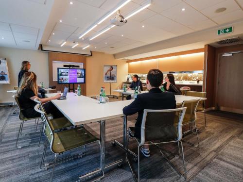 a group of people sitting at a table in a room at Novotel Luxembourg Centre in Luxembourg