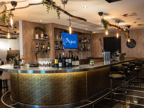 a bar in a restaurant with a counter with wine bottles at Novotel Luxembourg Centre in Luxembourg