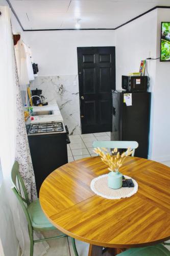 a kitchen with a wooden table and a kitchen with a refrigerator at Casa Emma Quepos in Quepos