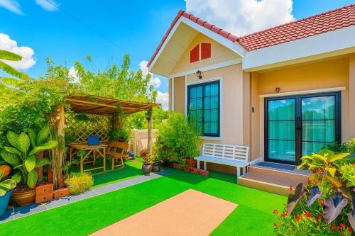 a small house with a green lawn in front of it at โฮมสเตย์บ้านญาติมุกดาหาร in Ban Muang Ba