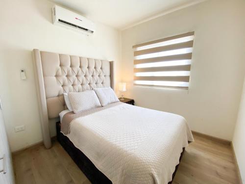 a bedroom with a large white bed with a window at Casa Elegante con alberca a 5 min Aeropuerto y Consulado in Hermosillo
