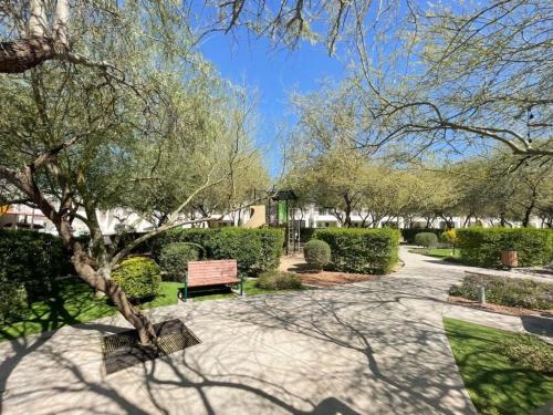 a park with a bench and trees and bushes at Casa Elegante con alberca a 5 min Aeropuerto y Consulado in Hermosillo