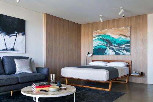 a bedroom with a bed and a couch and a table at Breathtaking Sydney Harbour Views from Stylish Harbourside Studio in Sydney