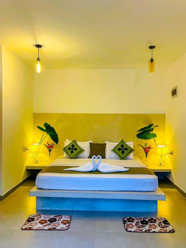 a bedroom with a bed with birds painted on the wall at The Mirror Wall Sigiriya in Sigiriya