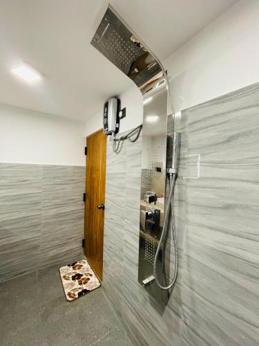 a bathroom with a shower with a glass door at The Mirror Wall Sigiriya in Sigiriya