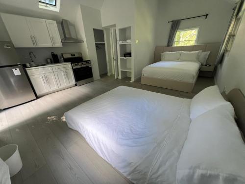 a bedroom with a large bed and a kitchen at Wainscott Woods Retreat in Wainscott