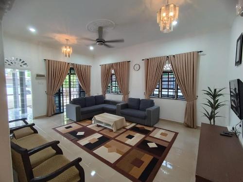 a living room with a couch and a table at Teratak Tuan Homestay in Gua Sai