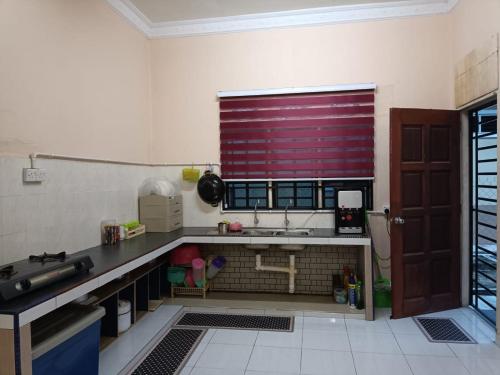 a kitchen with a sink and a red window at Teratak Tuan Homestay in Gua Sai