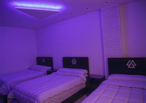 two beds in a room with purple lighting at Pyramids Sphinx VIEW Hotel in Cairo
