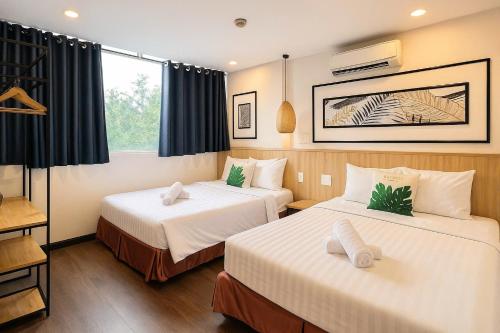 a hotel room with two beds and a window at Vintage Park View Hotel & Spa - Hoang Phi in Ho Chi Minh City