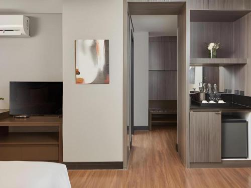 a room with a bed and a desk and a television at F1 Hotel Manila in Manila