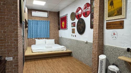 Cette petite chambre dispose d'un lit dans un mur en briques. dans l'établissement 台南民宿舞鶴, à Tainan