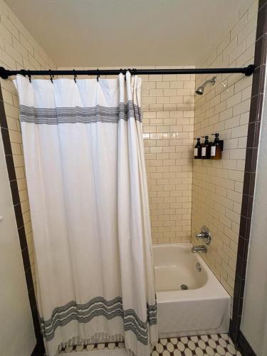 a bathroom with a shower curtain and a tub at The Gravity Getaway, it's all downhill from here in Bella Vista