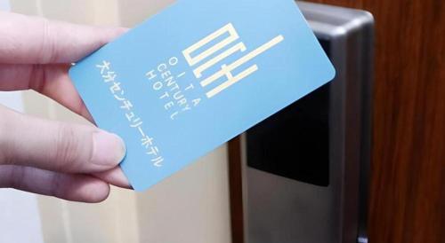 a person holding a piece of paper in front of a microwave at Oita Century Hotel in Oita