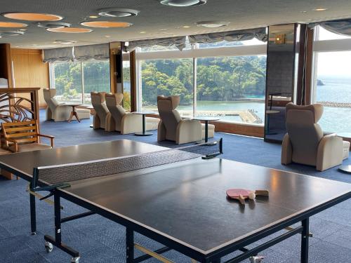 a room with a ping pong table and chairs at Nishiizu Matsuzaki Itoen Hotel in Matsuzaki
