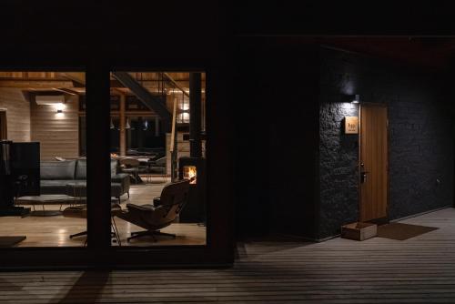 a view of a room with a chair through a window at Hygge Chalet Hakuba in Hakuba