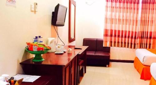 a hotel room with a desk and a tv and a room at Hotel Dynasty in Tarakan