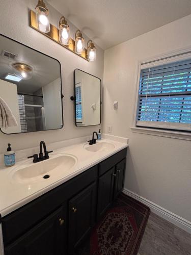 a bathroom with a sink and a mirror and a window at The Gravity Getaway, it's all downhill from here in Bella Vista