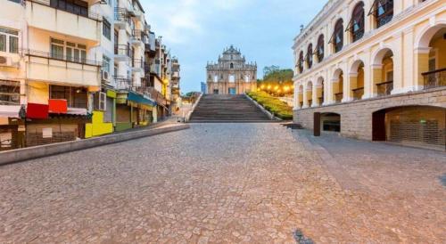 an empty street with a building in the distance at Happy Family Hotel in Macau