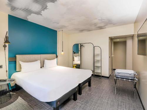 a large bed in a room with a blue wall at Ibis Malaga Centro Ciudad in Málaga