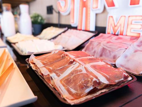 a row of trays of meat on a table at Ibis Malaga Centro Ciudad in Málaga