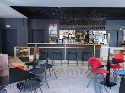 a restaurant with tables and chairs and a bar at Ibis Malaga Centro Ciudad in Málaga