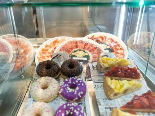 a display case filled with lots of different types of donuts at Ibis Malaga Centro Ciudad in Málaga