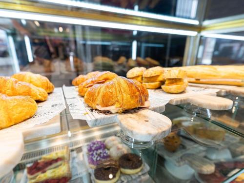 a display case with a bunch of pastries and bread at Ibis Malaga Centro Ciudad in Málaga