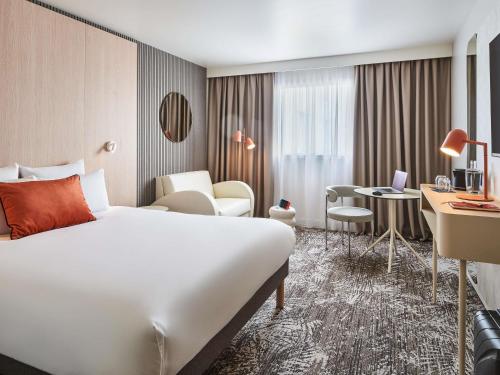 a hotel room with a bed and a desk at Novotel Paris 13 Porte d'Italie in Le Kremlin-Bicêtre