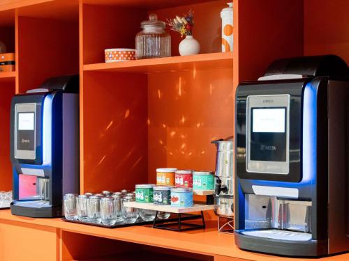 two machines are sitting on a shelf with drinks at Novotel Paris 13 Porte d'Italie in Le Kremlin-Bicêtre