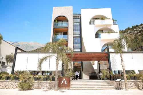 a building with palm trees in front of it at Amarea Boutique Hotel in Dhërmi
