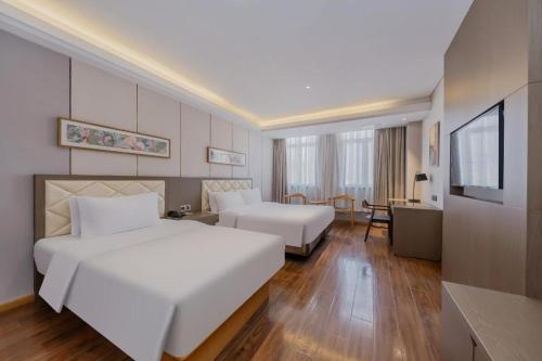 a hotel room with a large white bed and a desk at Yitel Shanghai Hongqiao Railway Station National Convention and Exhibition Center in Fangjiayao