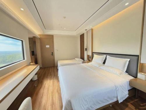 a hotel room with two beds and a large window at East Queen Hotel (Xi'an Beimen Metro Station) in Xi'an