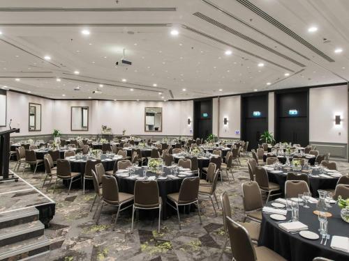 a large banquet hall with tables and chairs at Novotel Sydney International Airport in Sydney