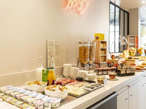 a buffet line with food and drinks on a counter at Ibis Centre Millau in Millau