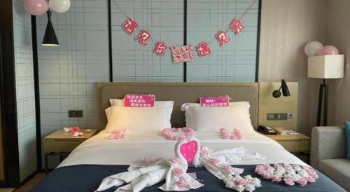 a bedroom with a bed with pink and white decorations at Echarm Hotel Nanning Chaoyang Square River View in Nanning