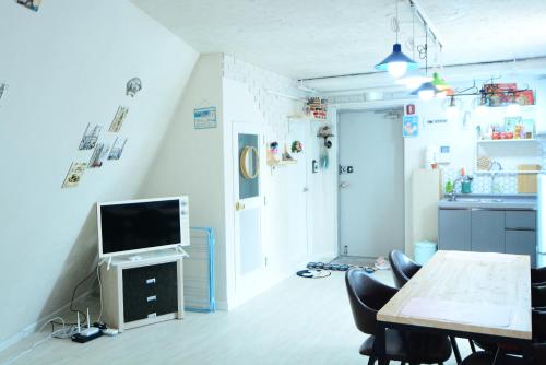 a living room with a television and a table at Residence Unicorn in Seoul