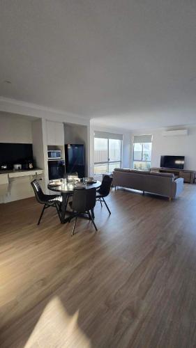 an empty living room with a table and chairs at Large bedrooms with bathrooms in each room in Armadale