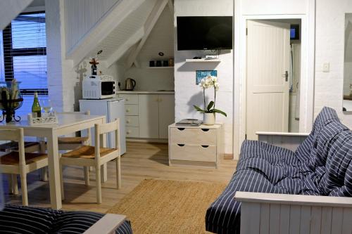 a kitchen and living room with a couch and a table at Rocklands Seaside Bed and Breakfast in Simonʼs Town
