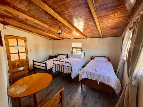 スクレにあるHostal Pachaのベッド2台が備わる木製の天井の客室です。