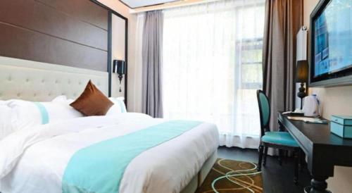 a bedroom with a bed and a desk and a television at Xana Hotelle Xi'an Zhonglou, Huimin Street Metro Station in Xi'an