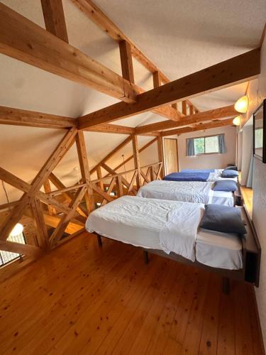 Dos camas en una habitación con suelo de madera. en 閼宗屋 Asoya, en Takamori