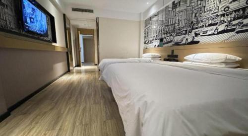 a bedroom with a bed and a flat screen tv at City Comfort Inn Shiyan Wudang Mountain in Danjiangkou