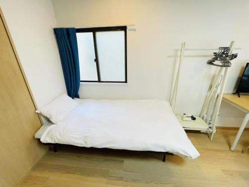 una cama en una habitación con ventana en モリアパートメント 203, en Tokio