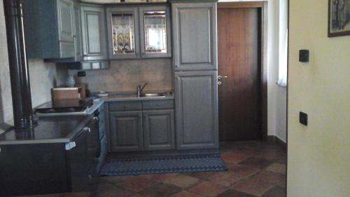 a kitchen with wooden cabinets and a sink and a door at Il Castellare in Gualdo Tadino