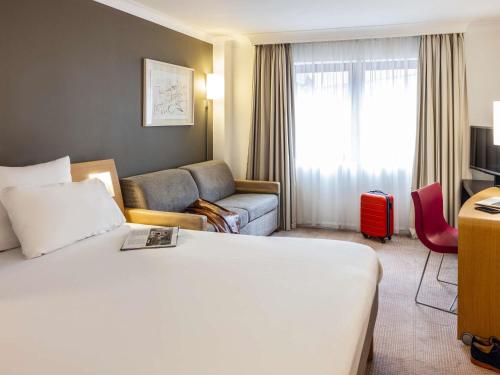 a hotel room with a bed and a couch at Novotel Bristol Centre in Bristol