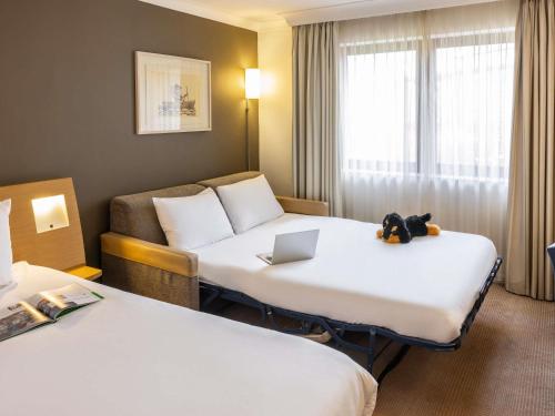 a hotel room with two beds with a laptop on them at Novotel Bristol Centre in Bristol